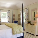Dormitor in stil clasic cu pat pe mijloc cu baldachin si perdele albe cu motive florale abastre